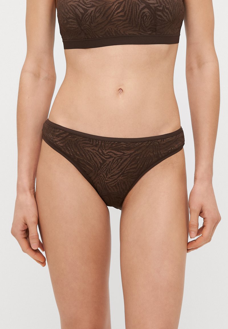 Bralette e calcinhas combinando com padrão animal castanho, feitos de um tecido transparente com uma textura suave e tiras elásticas para um ajuste confortável.