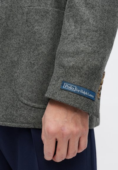 Szary wełniany blezer o fakturowanym wykończeniu, z niebieską metką "Polo by Ralph Lauren" i brązowymi guzikami na rękawie.