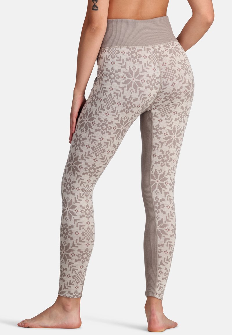 Musterleggings in Beige mit einem hohen gerippten Taillenbund, die ein geometrisches Design aufweisen und eine glatte, strukturierte Oberfläche haben.