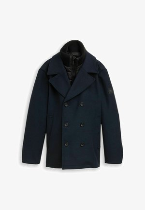Granatowy płaszcz dwurzędowy z teksturowanej tkaniny, z wysokim kołnierzem, czarną podszewką i czarnymi guzikami.