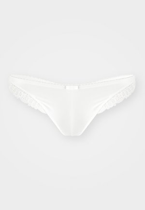 Balts zeķubikses ar gludu auduma virsmu, ar smalku mežģīņu apdari gar malām un mazām loka detaļām priekšpusē.