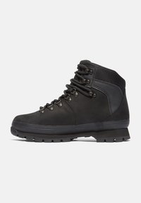 Scarpe da trekking nere con caviglia alta, tomaia in pelle, colletto in tessuto, occhielli in metallo e suola in gomma robusta per una buona aderenza.