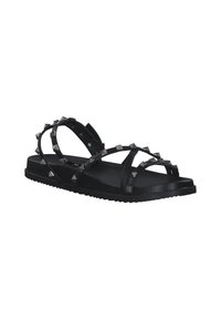 Black flat sandals with studded accents, featuring crisscross straps and a textured sole. Made of synthetic material.