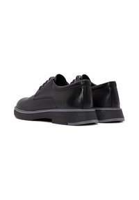 Zwarte leren schoenen met een gladde afwerking, lage profiel, ronde neus en een gestructureerde zwarte buitenzool met een grijze accenten. Oogjes voor veters zichtbaar.