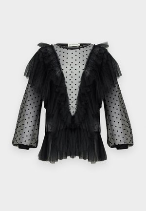 Blouse en tulle noir avec des pois, manches à volants, décolleté en V profond, texture superposée et détails froncés le long de l'encolure et de l'ourlet.