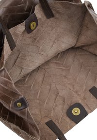 Brown woven bag with textured interior, features leather handles and brass hardware. Open design showcases a spacious, soft compartment.