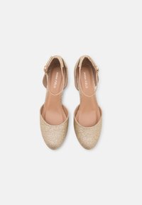 Gold glittered shoes with a pointed toe and ankle strap, featuring a smooth inner lining and a flat heel.