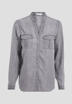 Chemise gris à manches longues boutonnée, avec un col et des poignets volantés, deux poches poitrine à rabat et une texture denim légèrement délavée.