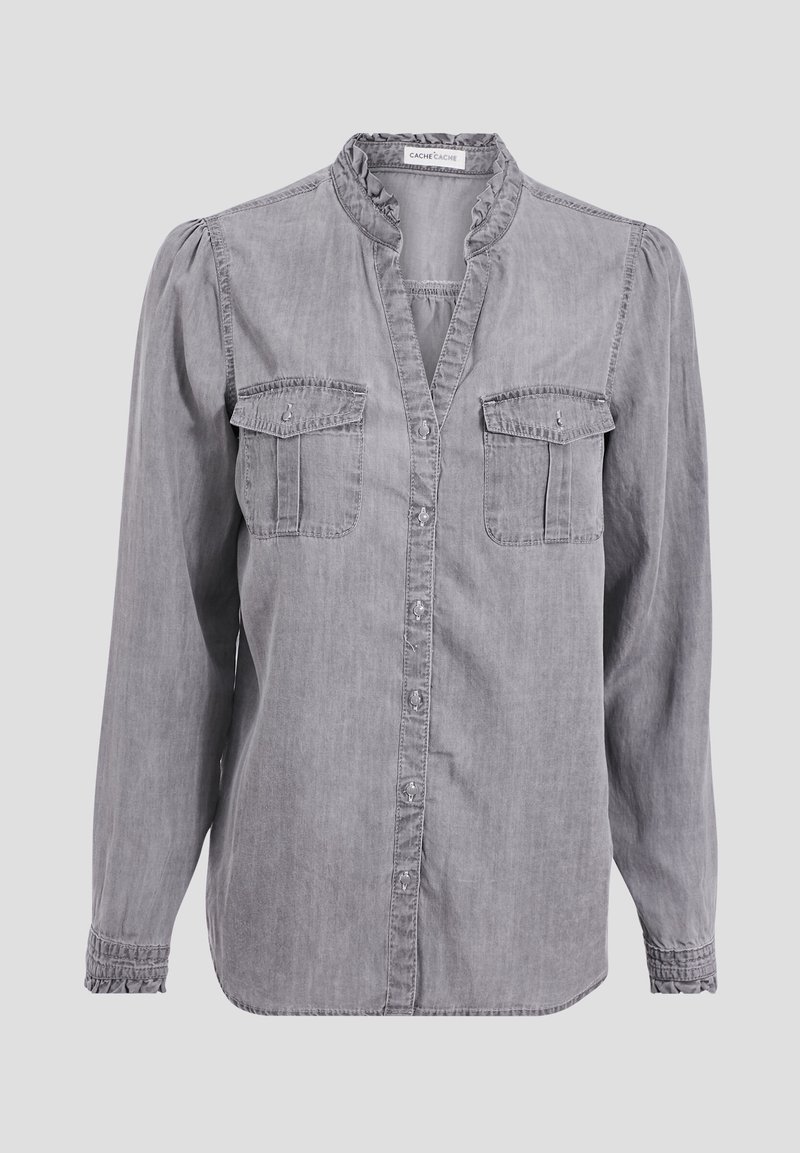 Chemise gris à manches longues boutonnée, avec un col et des poignets volantés, deux poches poitrine à rabat et une texture denim légèrement délavée.