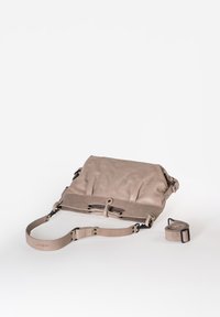 Beige leren tas met een gestructureerde afwerking, een verstelbare schouderband en een omvouwbare ontwerp, met zwart metalen beslag en een afneembare handgreep.