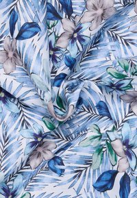 Tessuto azzurro chiaro con un motivo floreale che presenta foglie blu e verdi e fiori beige, texture liscia con dettagli del tessuto ben visibili.