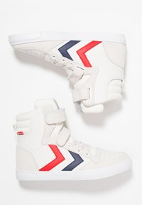 Höga sneakers med vitt tyg, grå accenter, röda och marinblå zigzag-mönster, med kardborreband och vita sulor.