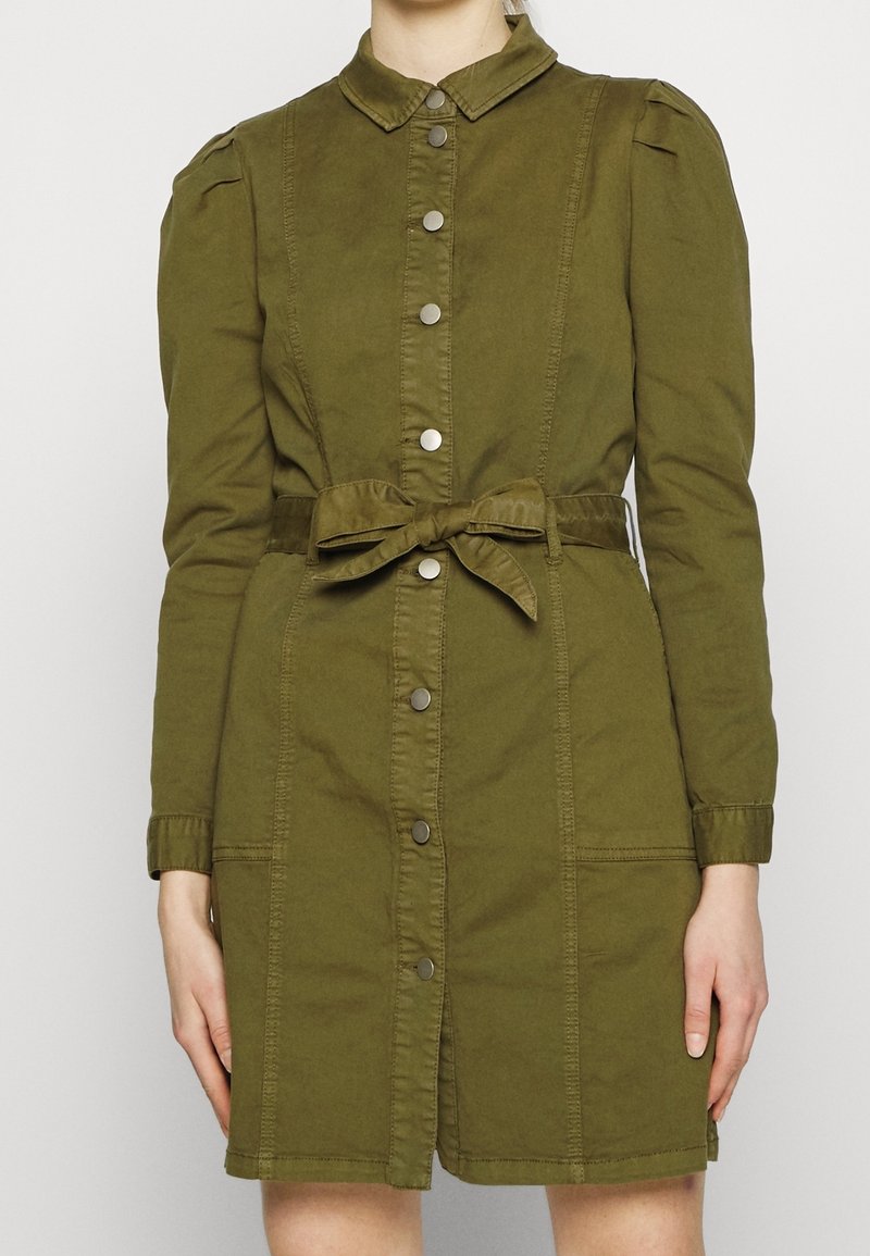 Abito verde oliva con bottoni, colletto, maniche a sbuffo, vita cintrata e due tasche frontali; realizzato in un tessuto leggero.