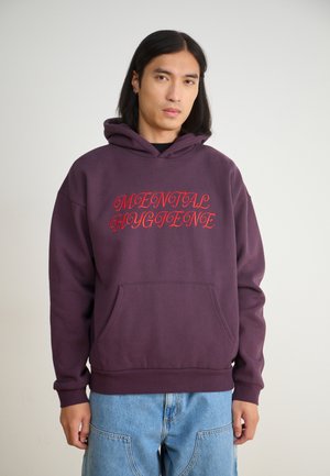 Purple hoodie with a front pocket, featuring the text "MENTAL HYGIENE" in bright red cursive. Made of soft, textured fabric.