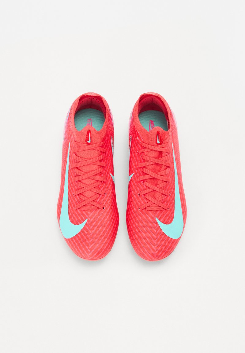 Rote Sportschuhe mit einer strukturierten Oberfläche, ausgestattet mit einem großen, hellblauen Nike-Logo, traditioneller Schnürung und einer gepolsterten Innensohle.