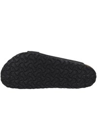 Semelle de chaussure en caoutchouc noir avec un motif texturé de vagues entrelacées. Design plat, bords arrondis et minimalisme de la marque pour un aspect épuré.