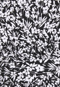 Černá tkanina s bílým květinovým vzorem, který zahrnuje listy a květy, s lehkou, mírně ribbovanou texturou.