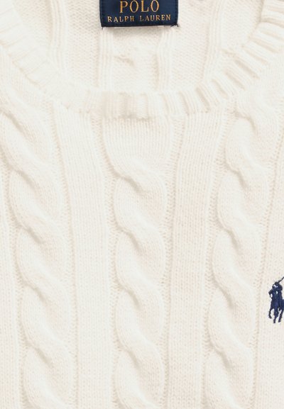 Pull en maille torsadée blanche avec étiquette Polo Ralph Lauren bleu marine et logo joueur de polo brodé sur la poitrine.