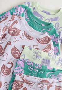 Vier gestapelte Baumwoll-T-Shirts mit verschiedenen Tiermustern. Die Farben sind minzgrün, lavendel, zartrosa und weiß mit braunen Akzenten.