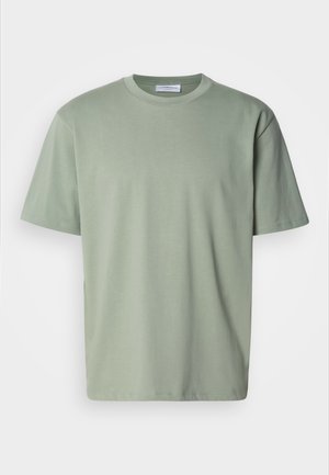 Camiseta de manga corta de color verde claro, hecha de algodón suave. Presenta un escote redondo y un corte relajado y recto. Diseño minimalista, sin estampados.