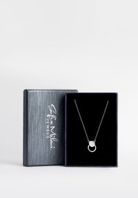 Sølv halskæde med en rund pendantsmykke med en krystalaccent, præsenteret i en gaveæske med sort fløjl og en struktureret sølvoverflade.