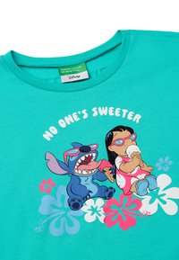 Turquoise t-shirt featuring a cartoon design of Stitch and Lilo with ice cream, surrounded by colorful floral accents and the text "NO ONE'S SWEETER."
