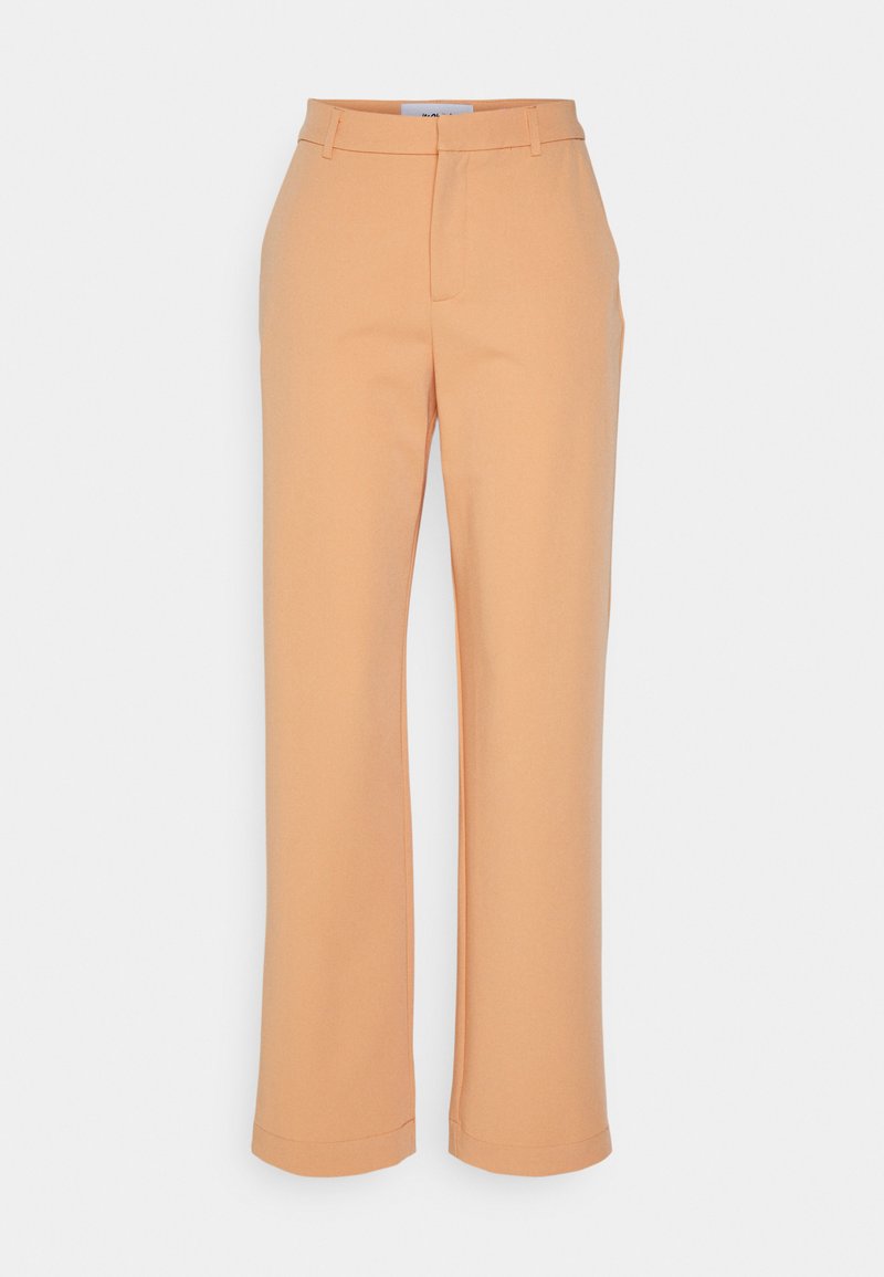 Calças de cor pêssego feitas de um tecido suave, com um design de perna reta, vincos fixos e uma bainha dobrada nas extremidades.