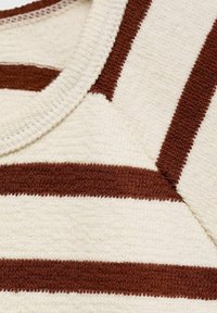 Striped cotton top featuring thick brown and cream horizontal stripes with a textured finish. Round neckline and ribbed edges.