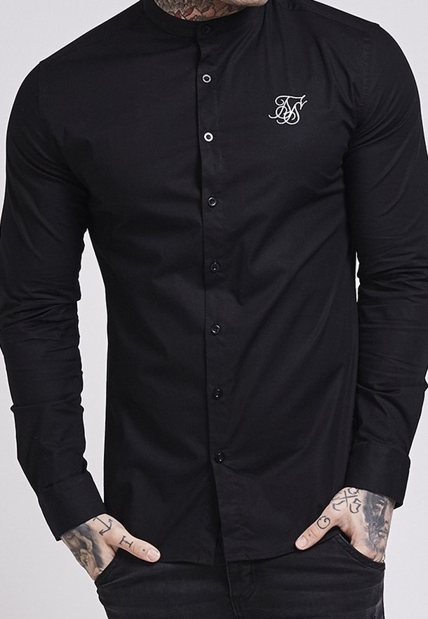 Zwart T-shirt met lange mouwen en een opstaande kraag, voorzien van een knoopsluiting aan de voorkant en een klein wit geborduurd logo op de borst.