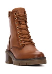 Botín de cuero marrón hasta el tobillo con cordones, ojales metálicos, cremallera lateral, punta redonda, suela gruesa y tacón de madera. Textura suave y acentos mínimos.