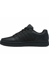 Černá sportovní bota s hladkým syntetickým svrškem, strukturálními bočními částmi, plochými tkaničkami a nízkým profilem podrážky. Obsahuje jemné perforace pro prodyšnost.
