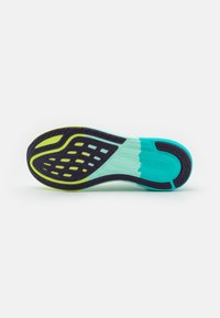 Semelle de chaussure avec un design multicolore comportant des accents noir, sarcelle et vert néon. Adhérence texturée et de nombreuses perforations pour la flexibilité.