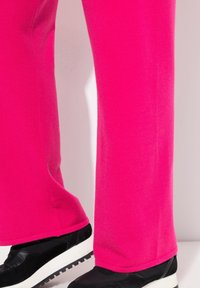 Fuksiapinkit legginsit, jotka on valmistettu pehmeästä ja joustavasta kankaasta. Suora lahje muotoilu. Yhdistetty mustiin lenkkareihin, joissa on valkoinen pohja.