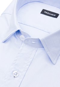 Jasnoniebieska, w paski koszula z klasycznym kołnierzykiem, z zapięciem na guziki i metką wewnętrzną z nazwą marki "PRÓCHNIK."