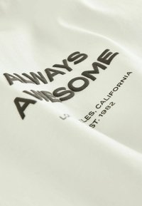 Tricou alb din bumbac, cu un text negru îndrăzneț care spune "ÎNTOTDEAUNA MINUNAT" și un text mai mic dedesubt, având o textură netedă și o croială lejeră.