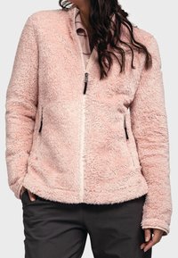 Puszysta, różowa kurtka na zamek z bocznymi kieszeniami, z miękką teksturą i ściągaczami na mankietach. Zamek błyskawiczny z metalowym uchwytem w kolorze srebrnym i czarnymi akcentami.