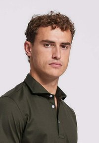 Donkergroen poloshirt met een puntige kraag, voorzien van een knopenlijst met witte knopen en een glad, gestructureerd stof.