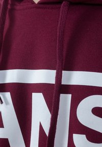 Felpa cap per la testa color bordeaux con logo grafico bianco. Il tessuto testurizzato presenta un cappuccio con cordini e polsini a coste.