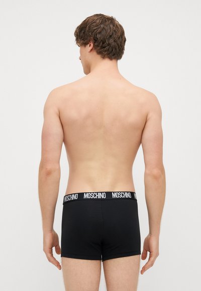Čierne boxerky s jemnou textúrou a elastickým pásom s logom, na ktorom je napísané "MOSCHINO" bielymi písmenami na kontrastnom čiernom pozadí.