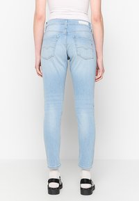 Lichtblauwe skinny jeans van denim, met een mid-rise taille, achterzakken met stiksel-details en een getailleerd silhouet.