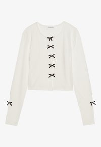 Weißes geripptes Langarm-Oberteil mit rundem Ausschnitt, ausgestattet mit schwarzen Bändern an der Vorderseite und an den Ärmelbündchen. Kurz geschnittenes Design.