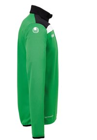 Grøn langærmet skjorte med sort krave og hvid stribe hen over brystet. Lavet af glat stof med et logo på skulderen.