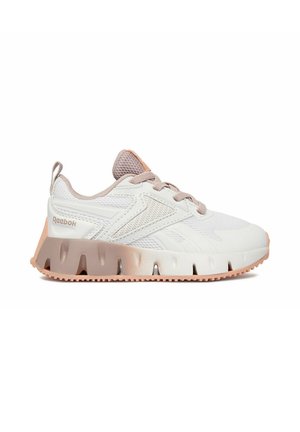 Scarpa da ginnastica Reebok bianca e beige con pannelli in mesh, chiusura con lacci e suola spessa e testurizzata vista di lato su sfondo semplice.