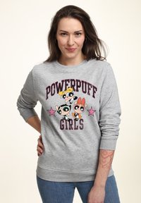 Felpa grigia con grafica delle "Powerpuff Girls", che presenta personaggi dei cartoni animati e stelle rosa. Maniche e orlo a coste, texture di tessuto morbido.