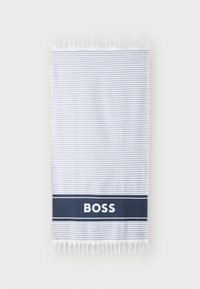 Stripet bomullhåndkle i hvit og grå, med en marineblå kant som har teksten "BOSS" i hvitt. Avsluttet med frynser.