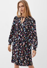 Schwarzes Kleid mit floralem Druck in Blau-, Rosa- und Brauntönen. Mit gerafftem Ausschnitt, langen Ärmeln und lockerer Passform.