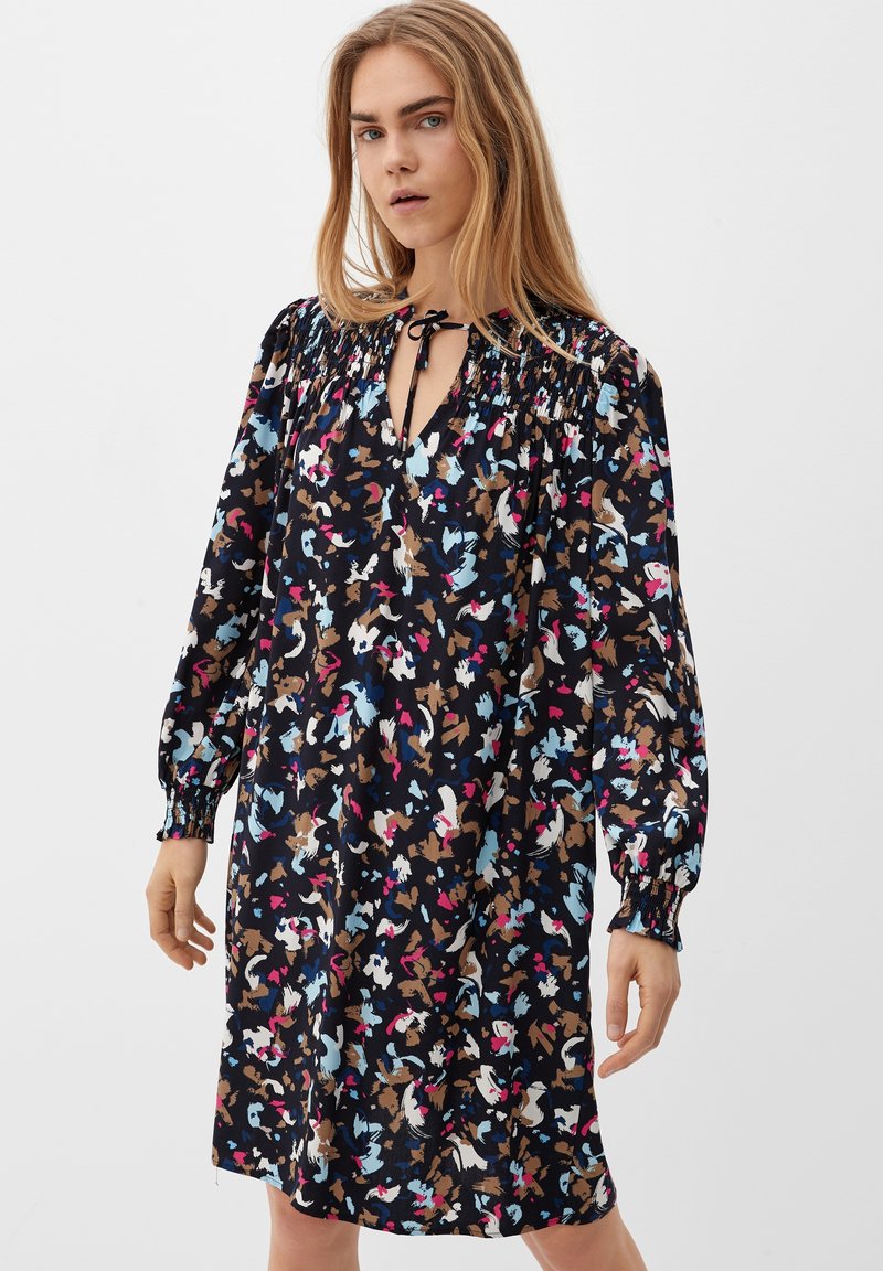 Schwarzes Kleid mit floralem Druck in Blau-, Rosa- und Brauntönen. Mit gerafftem Ausschnitt, langen Ärmeln und lockerer Passform.