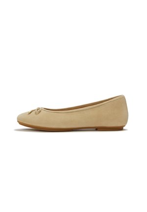 Scarpa ballerina piatta in camoscio beige con punta arrotondata, piccolo dettaglio con fiocco e suola piatta in gomma, mostrata di profilo.