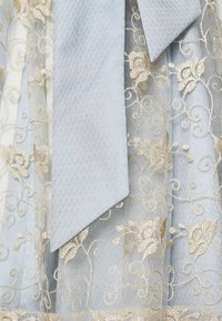 Abito azzurro chiaro con intricati ricami floreali dorati, caratterizzato da una texture liscia e una cintura in tessuto con un motivo diagonale.