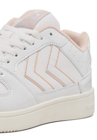 Weiße synthetische Sneaker mit zartrosa Akzenten und Zickzack-Mustern an den Seiten. Texturierte Sohle, Schnürdesign und gepolsterter Kragen.